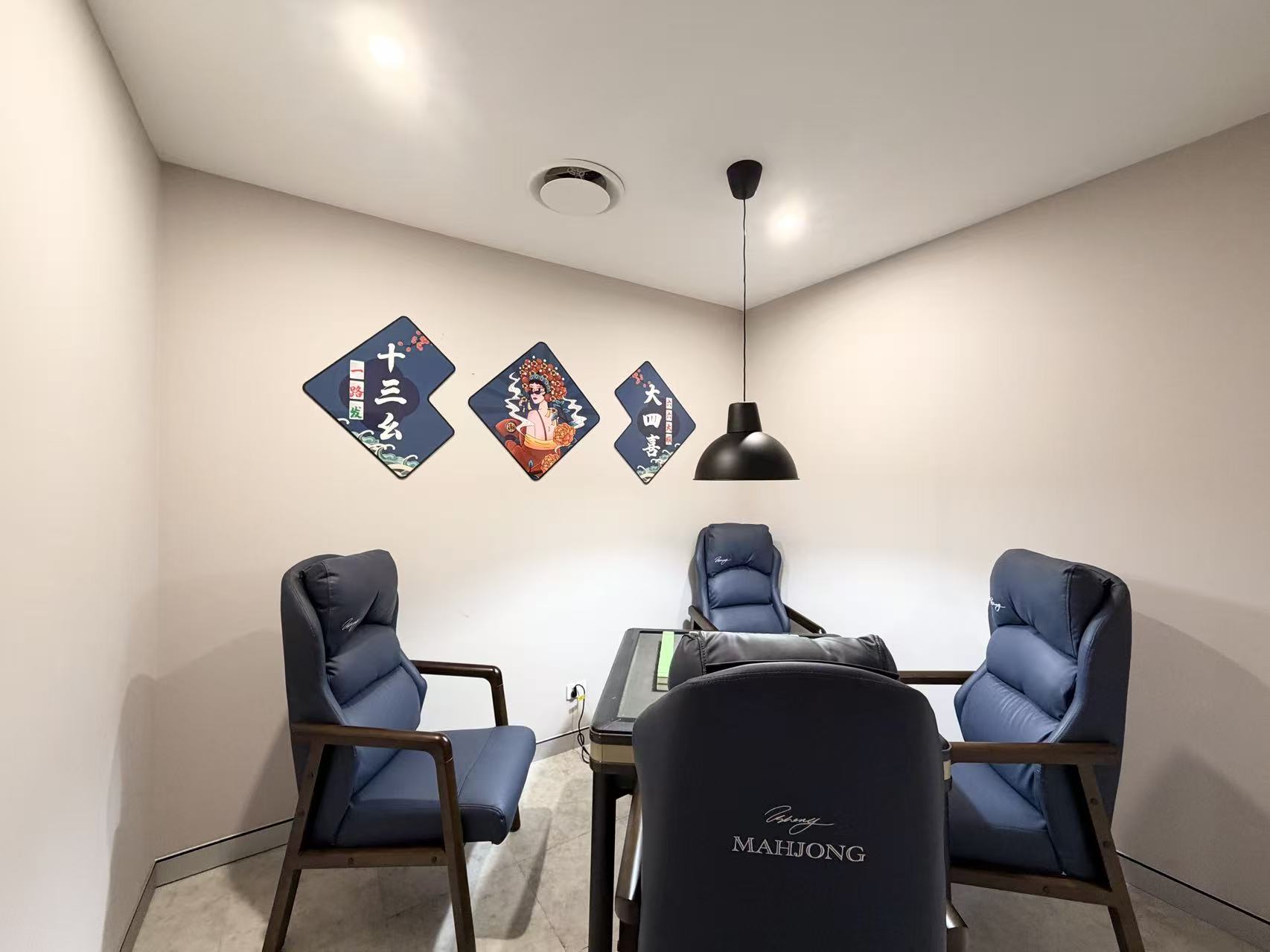 Inside a mahjong room: an automatic table ringed by stacked tile walls and four cushioned high-back chairs